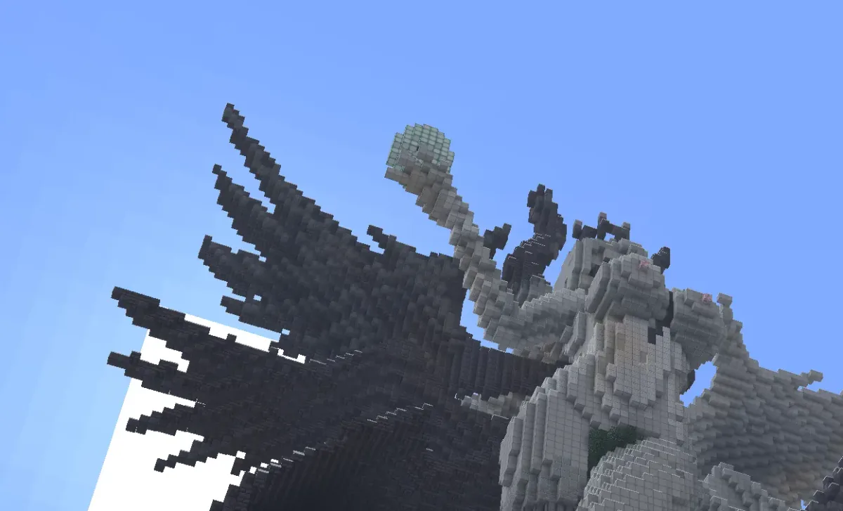 Giant winged warrior statue holding an orb, seen from below